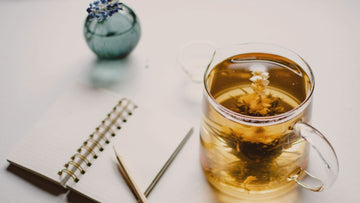 Open affirmations journal with a pen and a cup of tea in soft light, symbolizing gentle reflection, calm journaling and psychologist-designed self-help by Talk2Tessa.