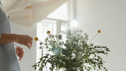 Calm woman standing among soft neutral flowers, reflecting gentle burnout recovery and psychologist-designed AI self-help by Talk2Tessa.