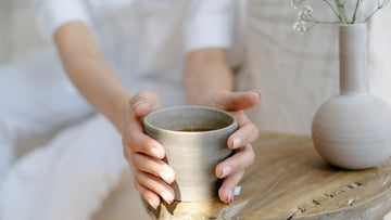Calm beige photo of a person holding a cup of tea, symbolizing rest, mindfulness, and burnout recovery. Psychologist-designed, AI-guided self-help by Talk2Tessa using ACT and self-compassion principles.