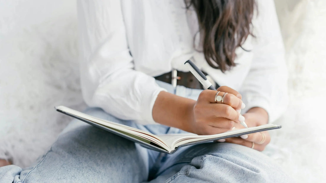 Woman journaling for Talk2Tessa self-doubt journal prompts and self-compassion reflection.