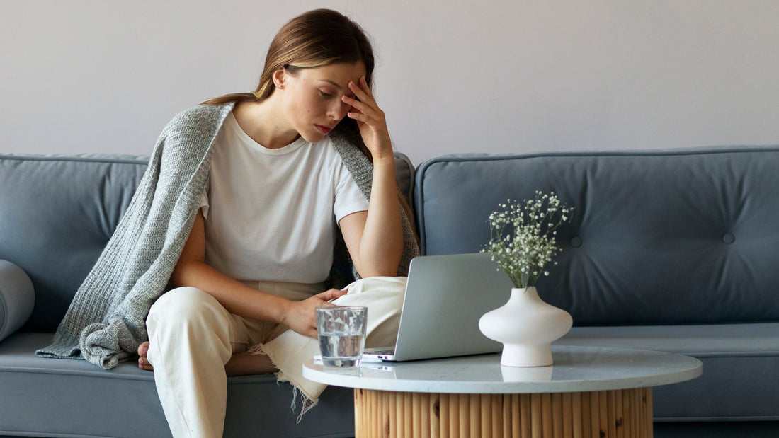 Woman resting on a couch, looking deeply tired and emotionally drained — representing invisible burnout recovery and gentle support by Talk2Tessa.