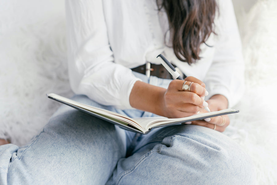 Hands journaling in soft natural light, representing gentle therapy journaling prompts for emotional clarity and self-compassion.