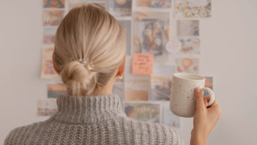 Woman creating a calm vision board at home, symbolizing gentle goal-setting and psychologist-written vision board affirmations.