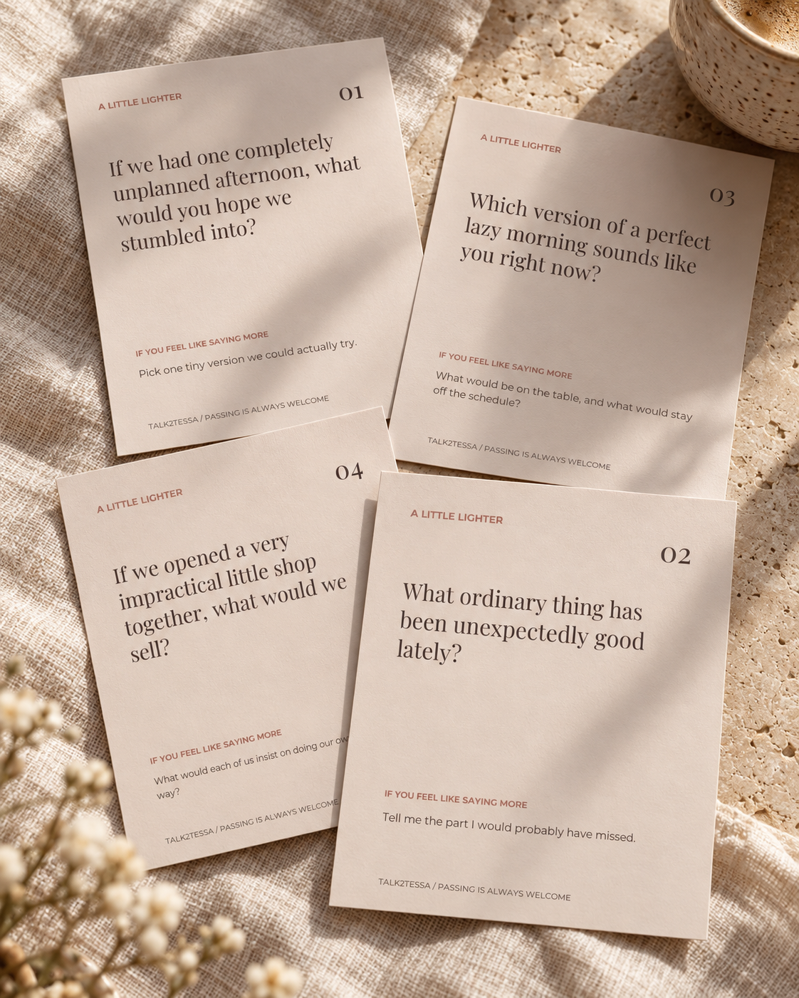 Styled mockup of four printable conversation cards on linen and stone
