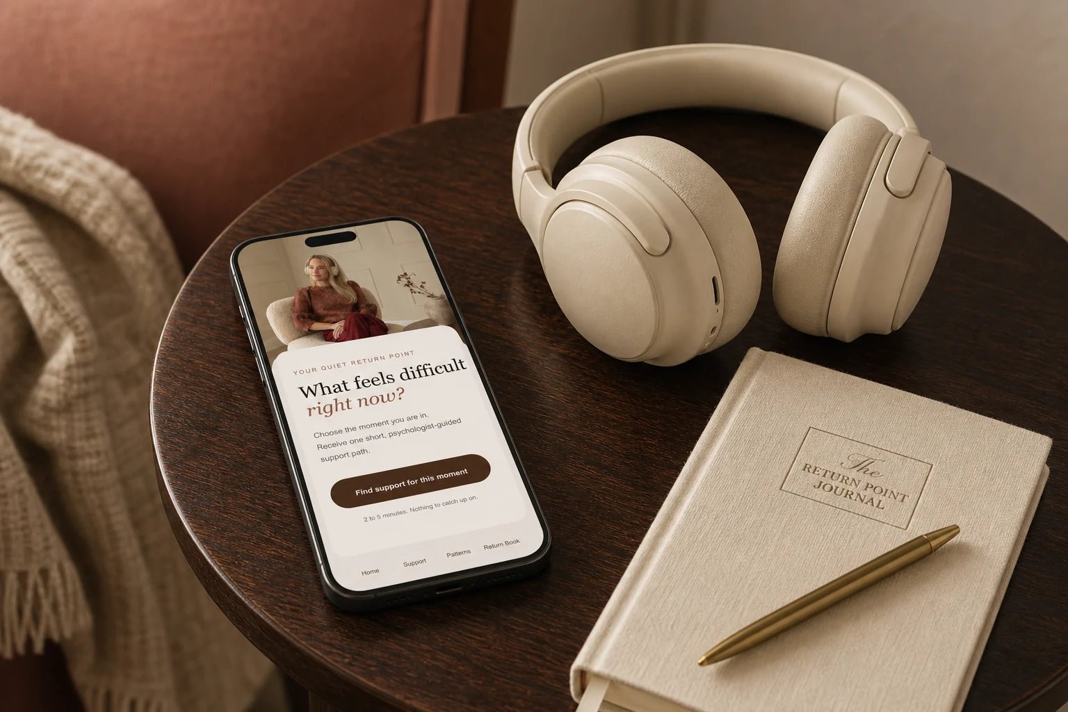 The Return Point open on a phone beside cream headphones and a private journal